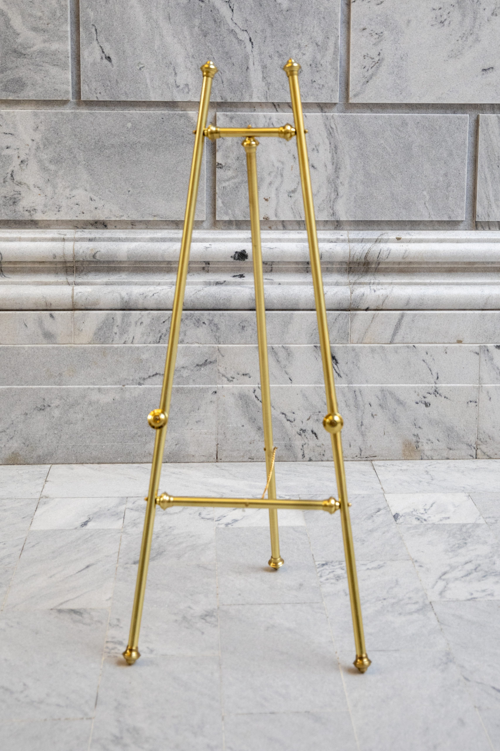 Gold easel on marble backdrop